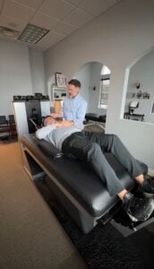 Dr. Wayne positioning a patient on the cervical DRX9000 spinal decompression machine for neck pain treatment at Frisco Spinal Rehab
